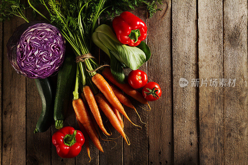 食物蔬菜彩色背景。美味新鲜的蔬菜在木桌上。顶部视图与复制空间。水平的。