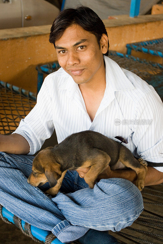 印度青年和小狗玩耍