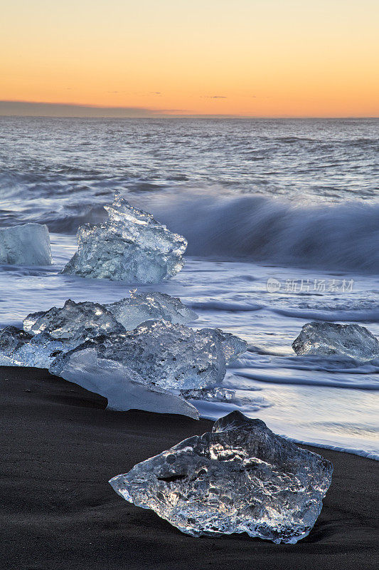 日出时冰岛Jökulsárlón海滩上的冰山