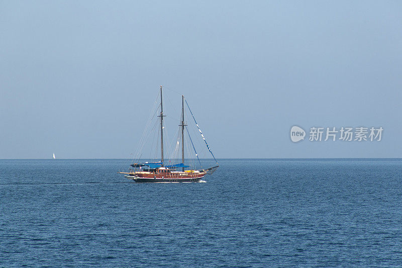 在土耳其穆格拉的马尔马里斯湾巡航的木制蓝色航行游艇