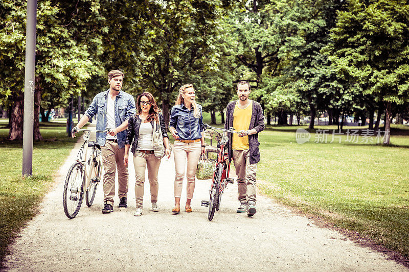 四个年轻人在城市公园骑自行车