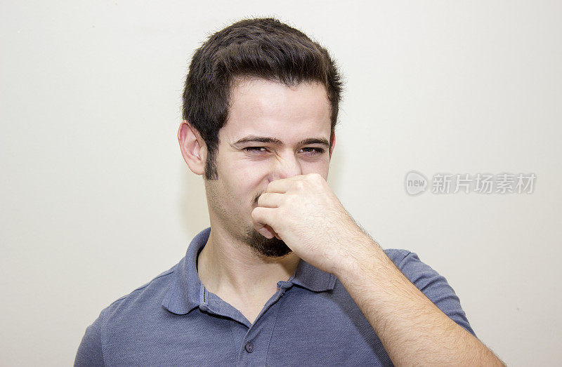 一幅焦虑地捏着鼻子的男人肖像