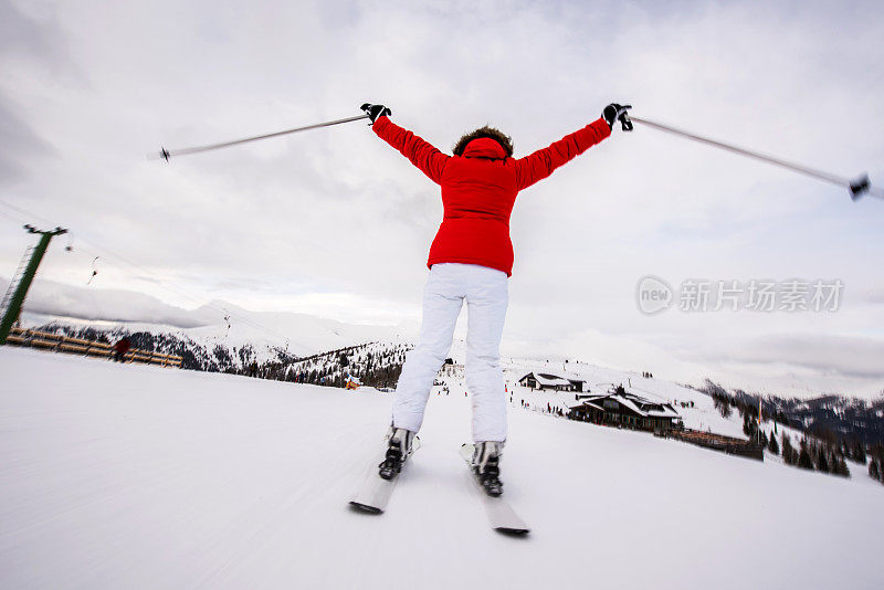 一个无忧无虑的滑雪者在滑雪时享受乐趣的后视图。