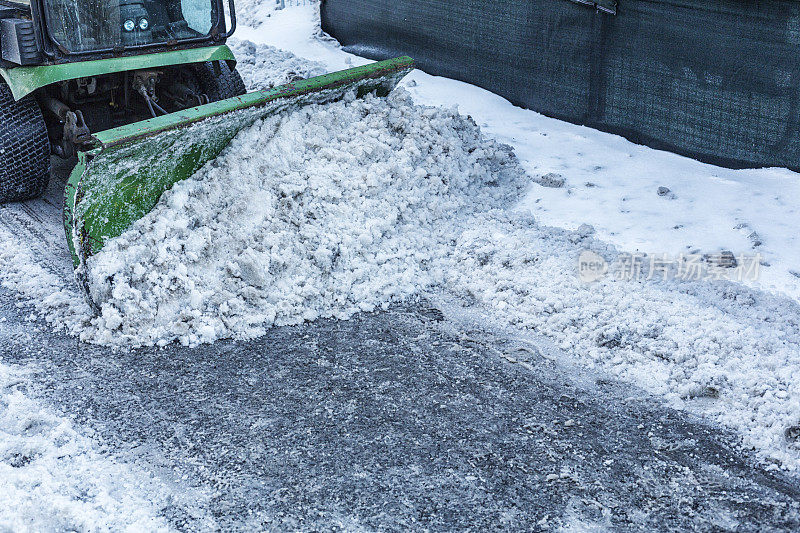 扫雪机清除泥泞的冬季雪从人行道