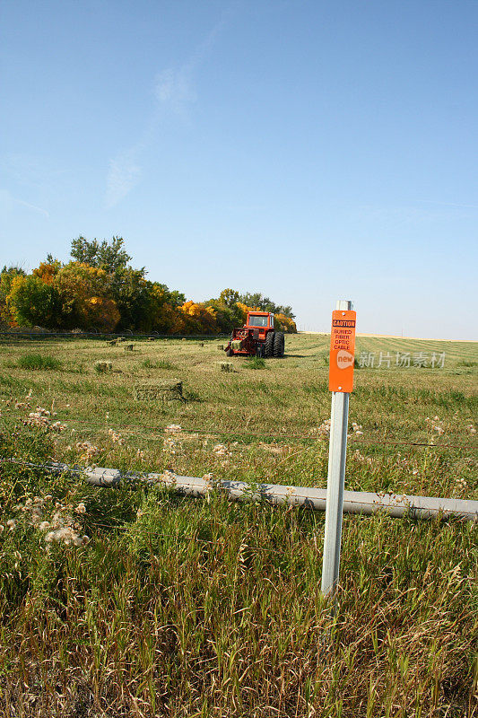 农田上的标牌上写着“小心埋在地下的光缆”