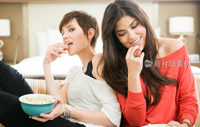 两个女人在吃一碗爆米花