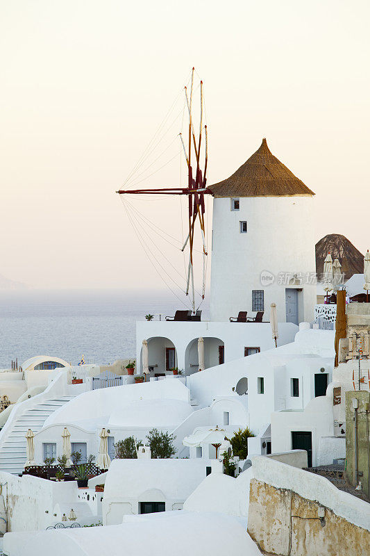 伊亚村日出时的风车。圣托里尼岛。希腊。