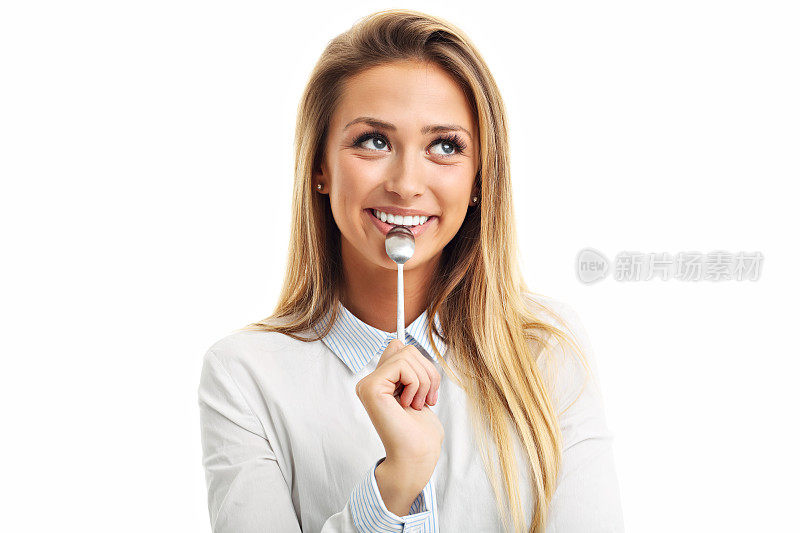 年轻的微笑女人的肖像勺子在她的嘴孤立在白色