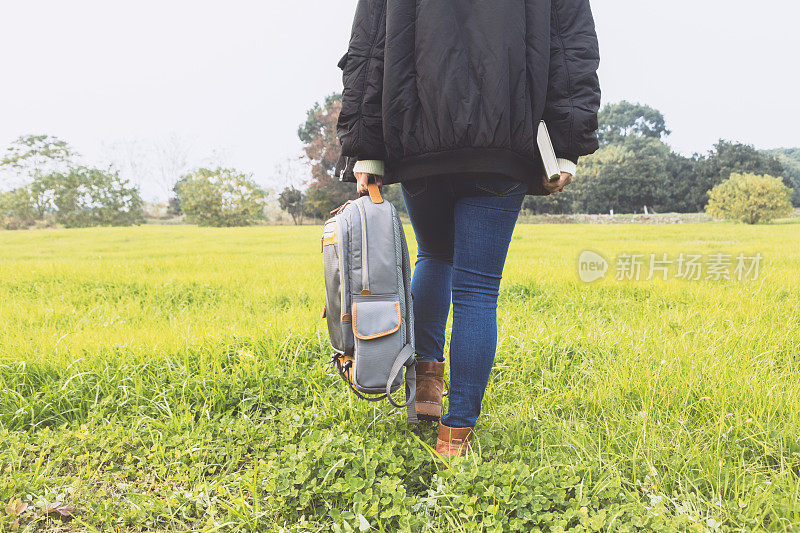 年轻女性背着背包在户外行走