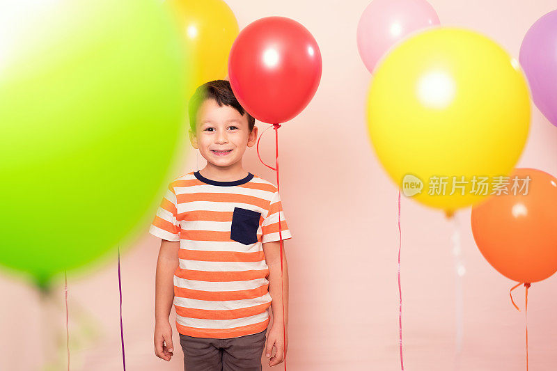 可爱的孩子在五颜六色的气球中。
