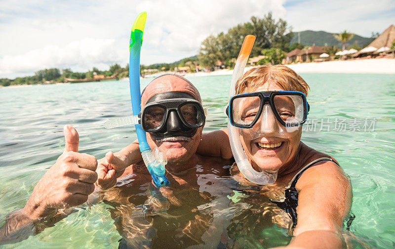 资深快乐夫妇在热带海洋远足与水相机自拍-船旅行浮潜在异国情调的场景-活跃的退休老人和有趣的概念在世界各地-温暖明亮的滤镜