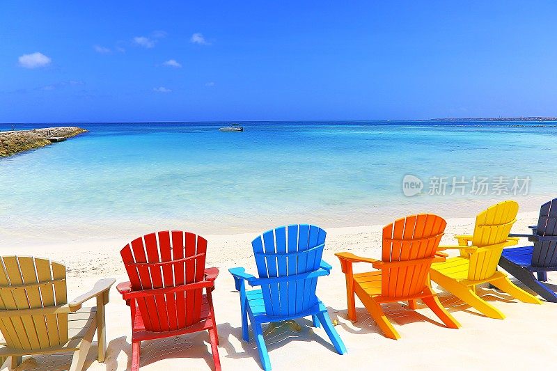 热带绿松石海滩与多彩的户外阿迪朗达克椅子，阿鲁巴，加勒比海