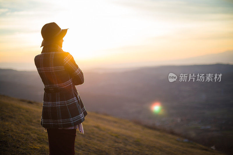 戴着帽子的时髦女人欣赏日落