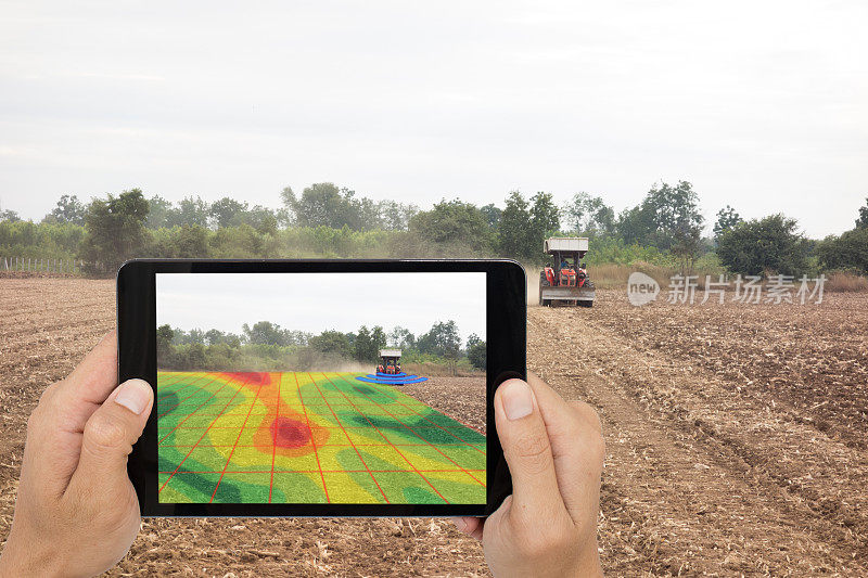 智能农业概念，农民使用平板读取红外拖拉机上的高清晰度土壤测绘，在耕作期间进行深层土壤扫描，包括有机，ec,om，氮，种子