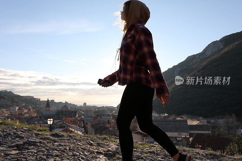 日出时，年轻女子在村庄和海面上行走