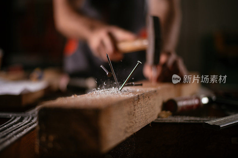 木匠在车间用锤子工作的特写