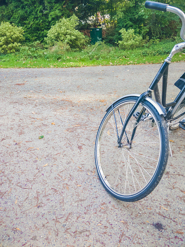 自行车的前轮踩在公园的碎石地上
