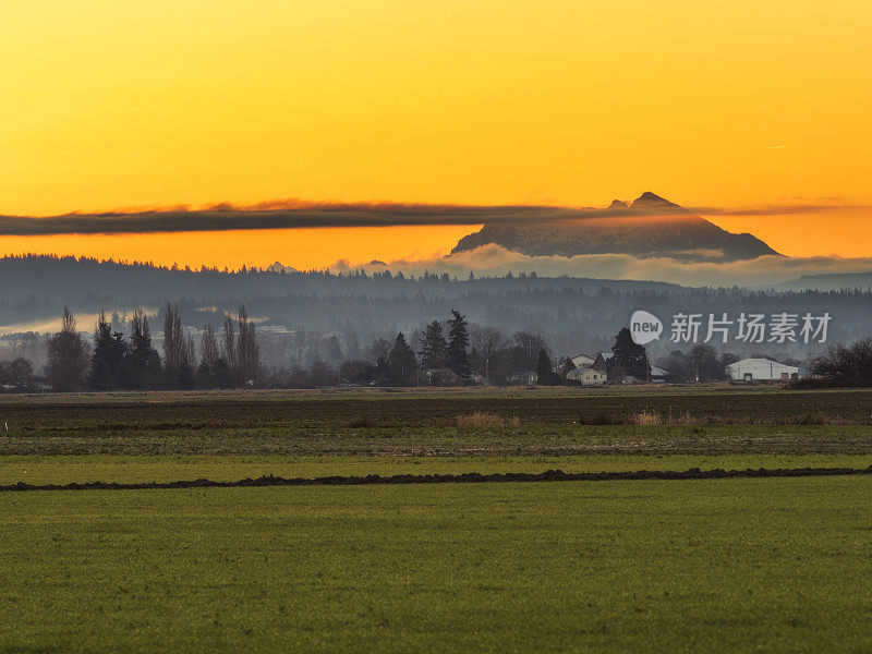 日落时分，风景如画的农田和雪山