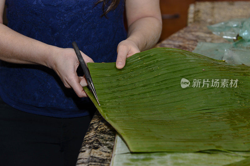 年轻女子正在切香蕉叶做玉米粉蒸肉