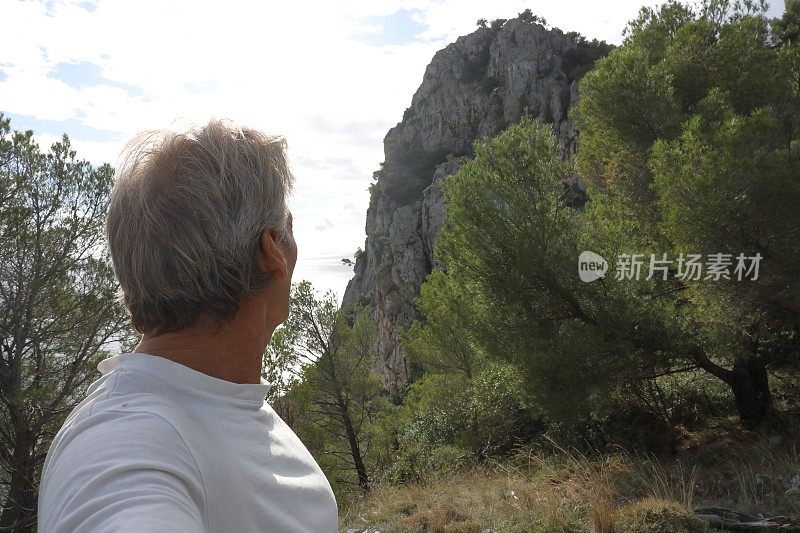 一个徒步旅行者在崎岖的海岸线上探索山丘