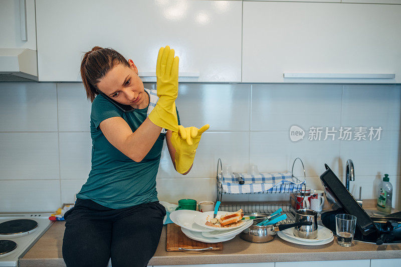 年轻的家庭主妇在厨房打电话