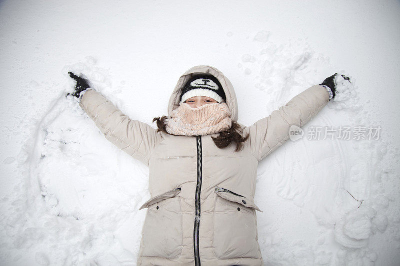 女孩躺在雪地里的地上