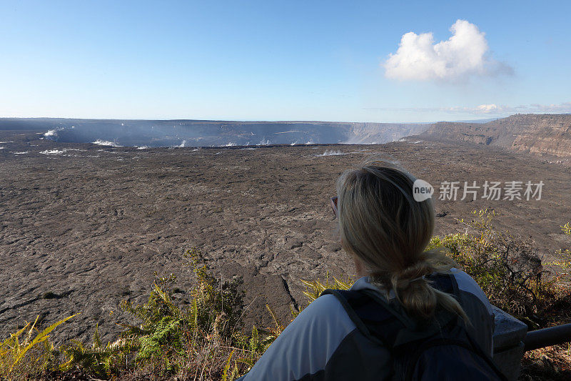 一名女性徒步旅行者眺望远处的火山熔岩