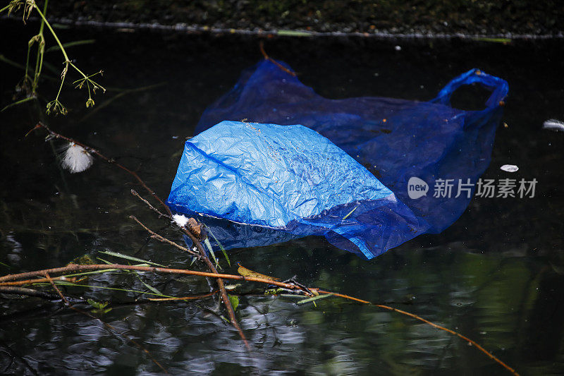 蓝色塑料袋漂浮在米查姆池塘的水