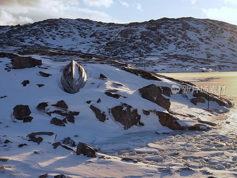 返回的船在冰封的峡湾边的雪地上