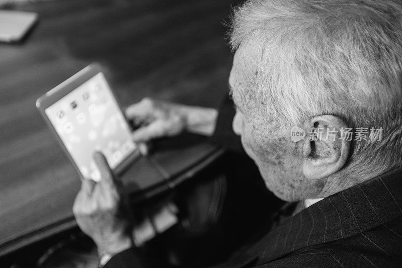 老人在用平板电脑。