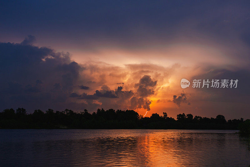 闪电在河流的倒影中闪现。自然灾害。夜晚漆黑戏剧化的天空。可怕的云。危险的天堂。暴风雨天气。夏雨。自然背景。多雨的季节。神秘的景观