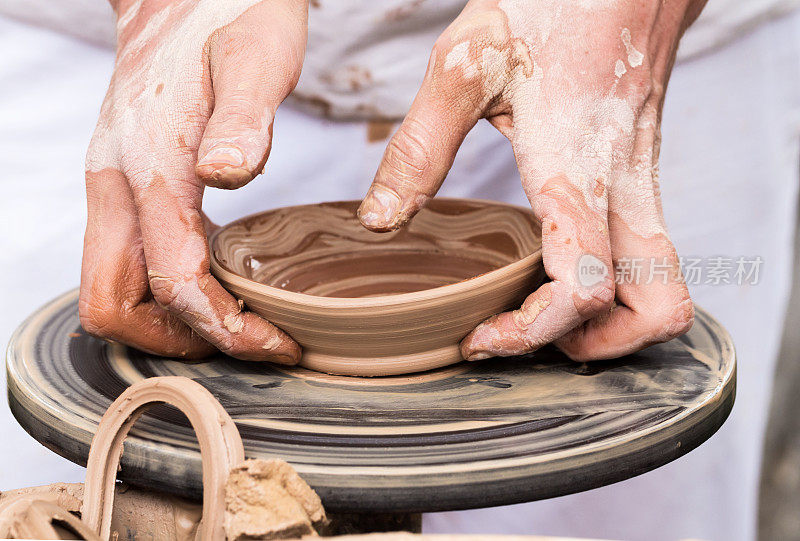 手在陶工的转盘上制作陶器。