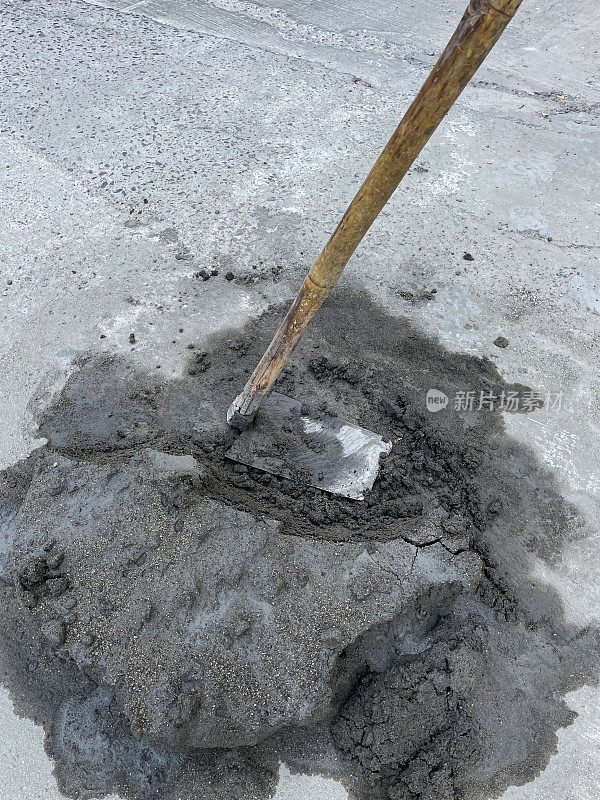 长柄混凝土摊铺机将湿水泥放置在混凝土路面表面的图像，工作工具，高架视图