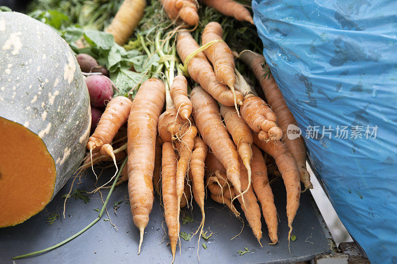 户外农贸市场的桌子上摆放着有机胡萝卜