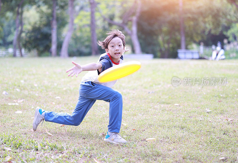 小男孩在公园里玩飞盘