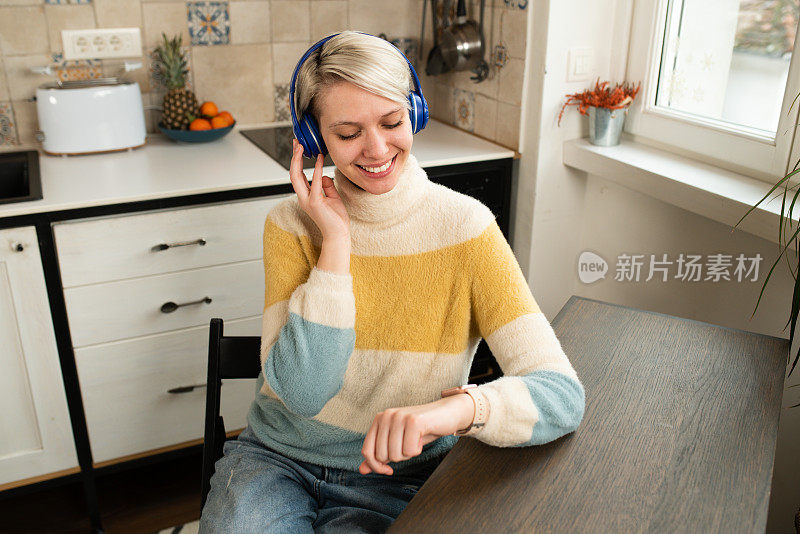 年轻的女人在家里听着音乐，享受着