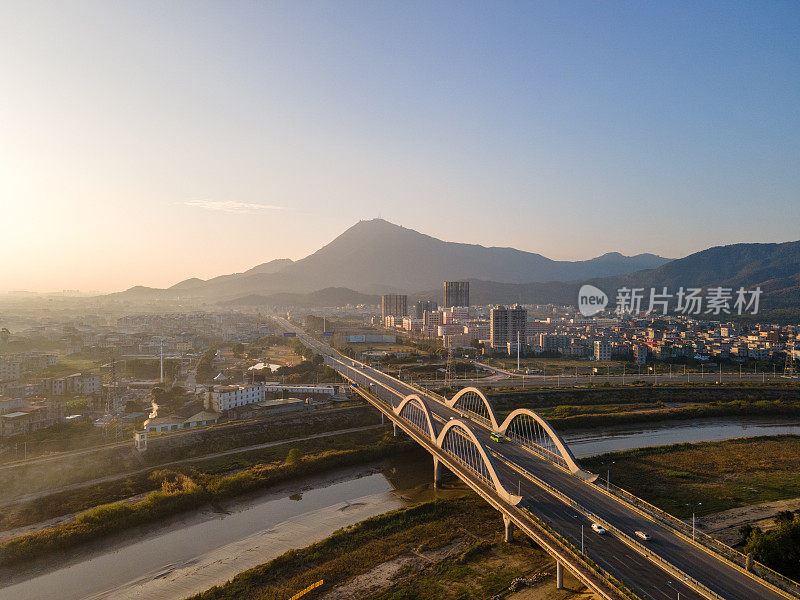 夕阳下桥跨江面，城镇沿江而上