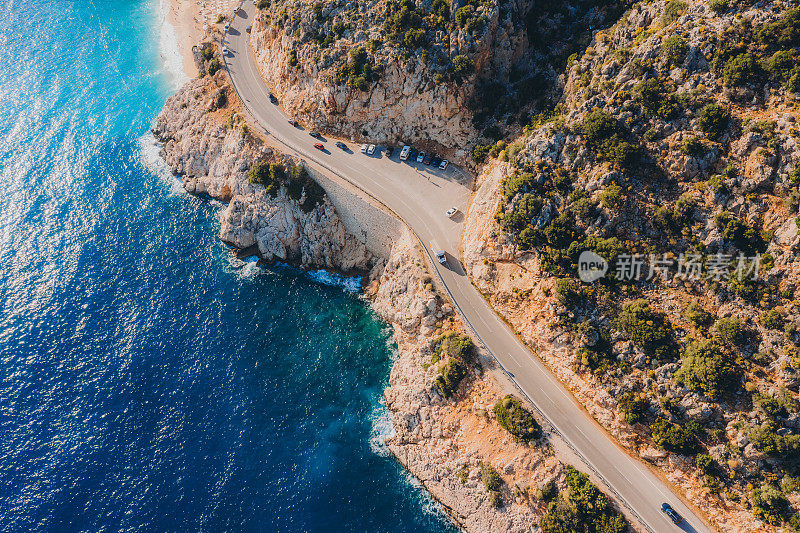 鸟瞰风景如画的绿松石海滩，在地中海土耳其的悬崖上蜿蜒的道路