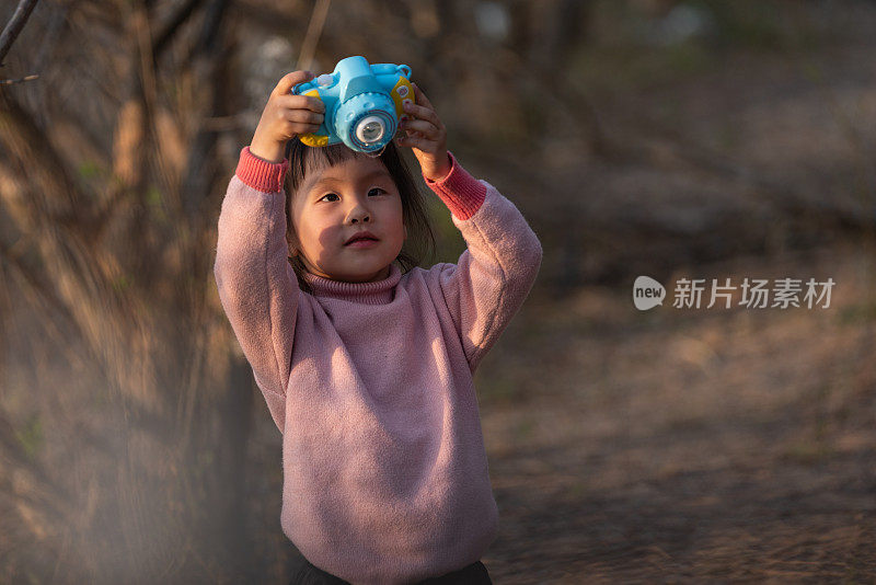 一个中国小女孩正在梅林里玩泡泡玩具