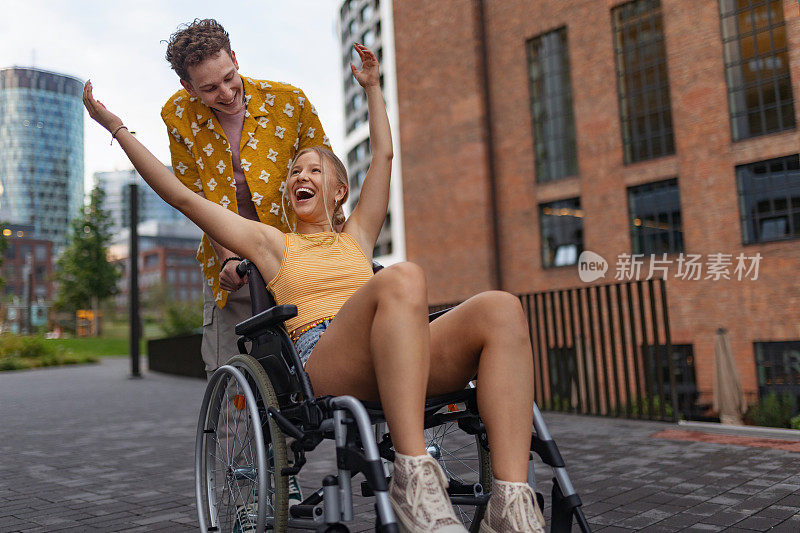 漂亮的Z世代女孩和她男朋友坐在轮椅上。Z世代的包容、平等和多样性。