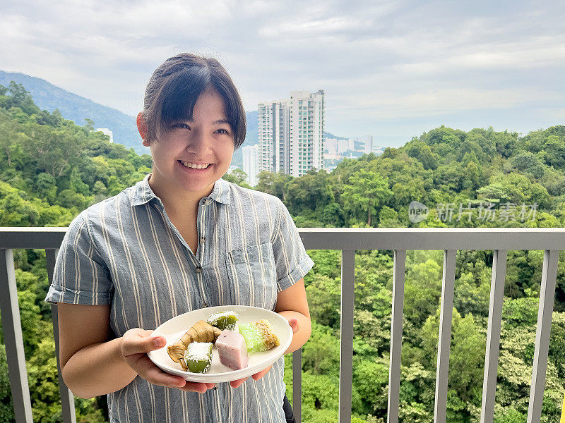 多种族妇女在公寓阳台上提供传统的娘烧饼