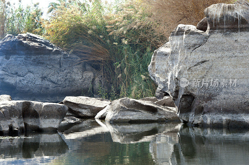 在阿斯旺，上尼罗河，埃及的瀑布浅岩地区，岩石水边缘的场景。
