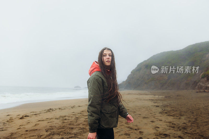 在加利福尼亚旧金山的海滩上散步的女人在思考下雨天