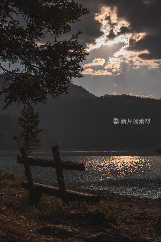 阳光下的木凳，可以看到美丽的山景和湖景