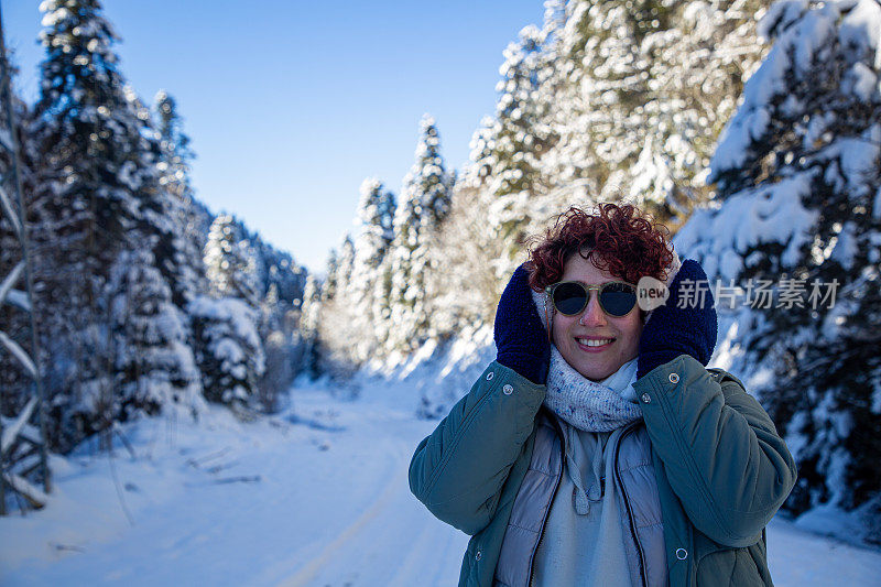 美丽的女人和冬天被雪覆盖的树