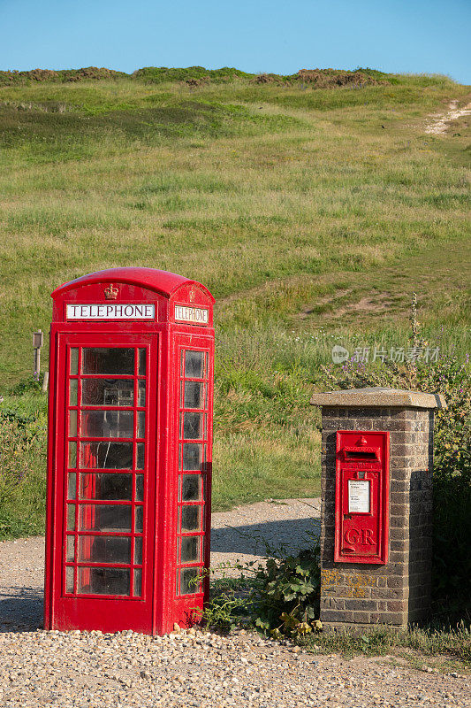 一个标志性的红色英国电话亭矗立在一个旅游景点的邮筒旁边
