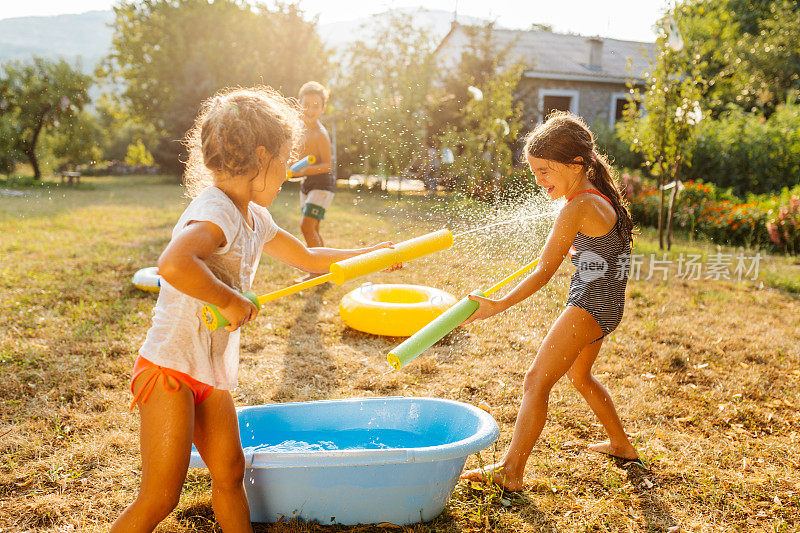 炎热的夏日，孩子们在院子里打水仗