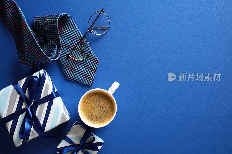 时尚男士礼品套装，咖啡，眼镜，蓝色背景领带，完美的快乐父亲节的主题。
