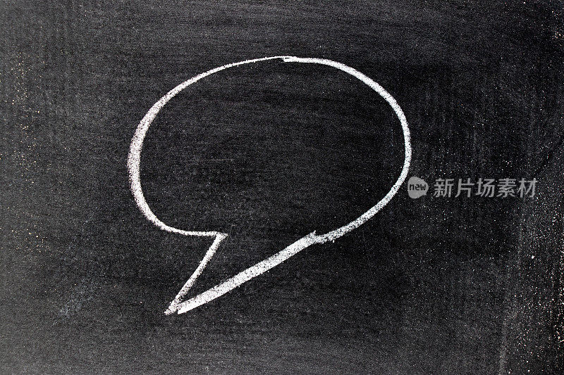 白色粉笔手在圆形气泡语音形状与空白在黑板背景