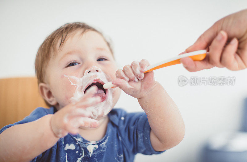 父母用勺子喂幼童